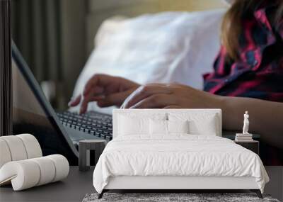 girl freelancer hands type on black laptop keyboard in bedroom close-up Wall mural