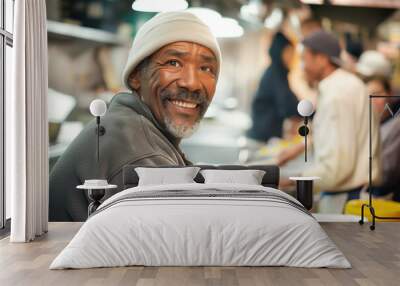 Joyful old homeless man laughs at dinner in soup house portrait. Senior vagrant finds free food and shelter in dosshouse. Charity work Wall mural