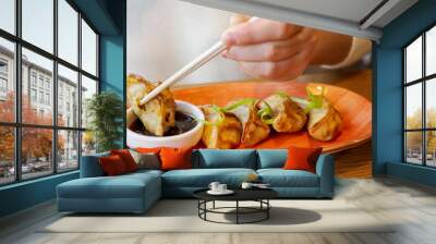 Young woman eating japanese gedza dumplings in cafe. Wall mural