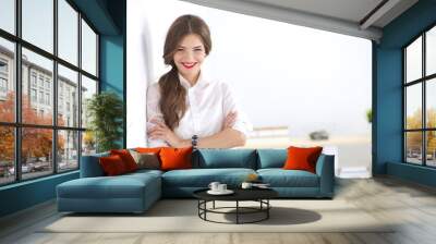 Attractive businesswoman standing near wall in office Wall mural