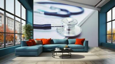 Medical equipment: blue stethoscope and tablet on white background. Medical equipment Wall mural