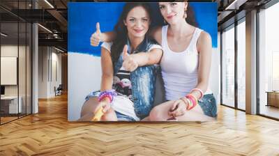 Two Beautiful young woman doing wall painting, sitting. Two Beautiful young woman. Wall mural