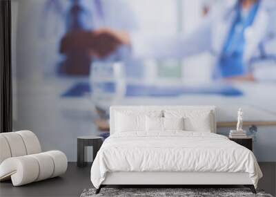 Two happy smiling young medical people handshaking at office Wall mural