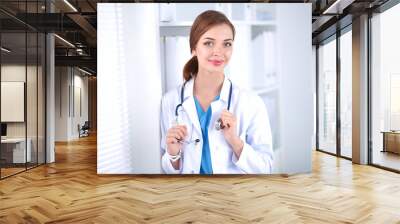 Woman doctor is standing near window  Wall mural