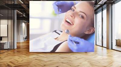 Young Female patient with open mouth examining dental inspection at dentist office. Wall mural