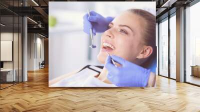 Young Female patient with open mouth examining dental inspection at dentist office. Wall mural