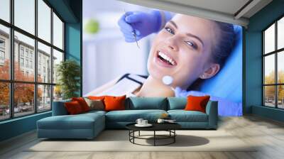 Young Female patient with open mouth examining dental inspection at dentist office. Wall mural