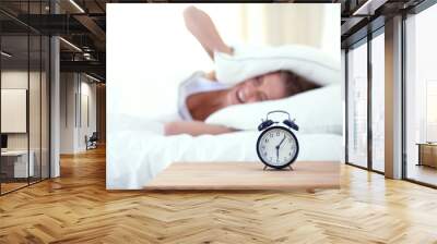 Young sleeping woman and alarm clock in bedroom at home. Young sleeping woman. Wall mural