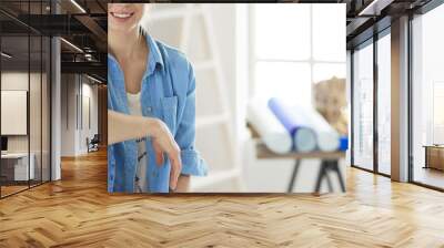 Young woman sitting at home and buying new furniture over the Internet using a tablet computer Wall mural