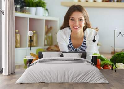 Young woman standing near desk in the kitchen Wall mural