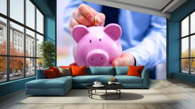 Businessman holding piggy box ,standing in office Wall mural