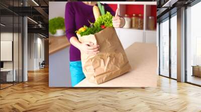 Healthy positive happy woman holding a paper shopping bag full Wall mural