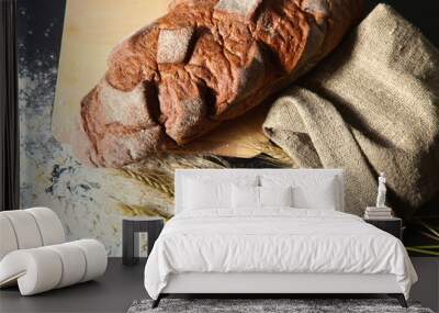 rustic crusty bread and wheat ears on a dark wooden table Wall mural