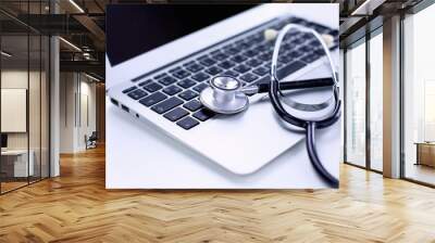 Stethoscope lying on a laptop keyboard in a concept of online m Wall mural