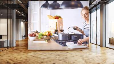 Young Woman Cooking in the kitchen. Healthy Food Wall mural