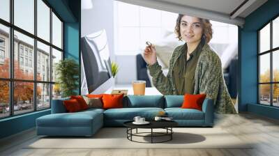 Young woman working with graphic tablet in office Wall mural