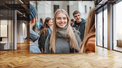 A lively group of young adults enjoying a walk in the city dressed in casual winter attire highlighting friendship social interaction and the vibrant energy of urban life in cold weather Wall mural