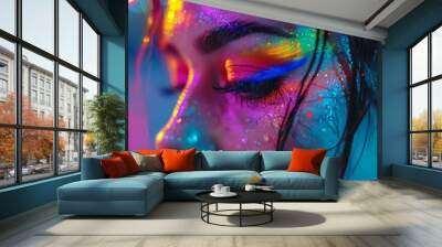 Close up of a womans face with neon makeup highlighting creativity and futuristic beauty in a vibrant colorful setting. Wall mural