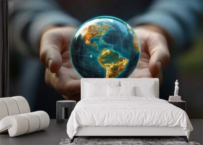 Hand holding a miniature globe with clear blue waters and lush continents representing global conservation efforts Wall mural