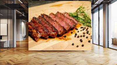 A piece of tenderloin meat is cut into six pieces and is sitting on a wooden cutting board Wall mural