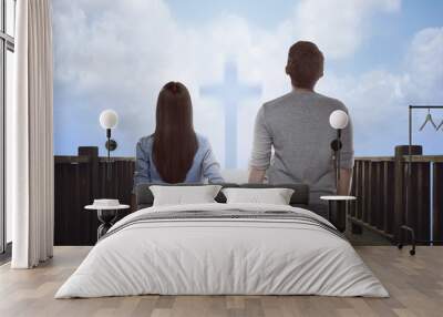 Asian couple looking at bright cross sign Wall mural