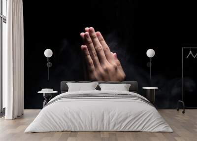 Hands with praying gesture over dark background Wall mural