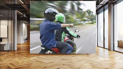 Rear view of passenger directing the way to motorcycle taxi driver Wall mural