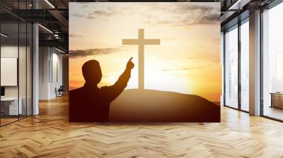 Silhouette of businessman pointing Christian cross on the hill Wall mural