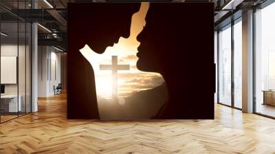 Silhouette of young couple looking at each other with christian cross Wall mural