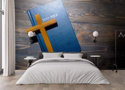 Wooden religion cross and blue book with the word Holy Bible. It is laying on a wooden table. Christian background, worship, church, symbols, praying concept. Symbol of faith in God, Christianity Feas Wall mural