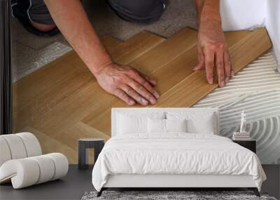 Worker laying parquet flooring. Worker installing wooden laminate flooring Wall mural