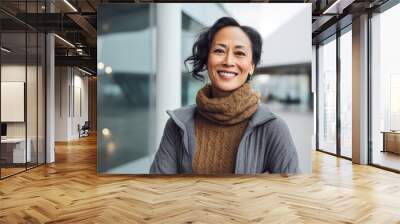 portrait of a happy Filipino woman in her 50s wearing a cozy sweater against a modern architectural background Wall mural