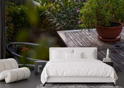 wooden table with potted plants and two metal chairs Wall mural