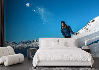 Happy young girl playing snowball fight on the winter snow day Wall mural