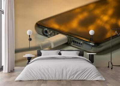 USB cable with smartphone on nightstand at night. Wall mural