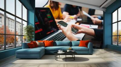 Close-up of female hands typing on smartphone. Working process in business office. Coworking people with laptop meeting in open space room Wall mural