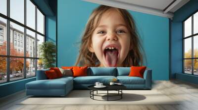 A child girl open her mouth and show her tounge Wall mural