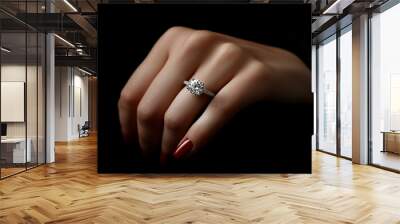 Gros plan d'une bague en or blanc sertie de diamant portée par une main manucurée sur un fond noir en soie, joaillerie de luxe pour mariage ou fiançailles	 Wall mural