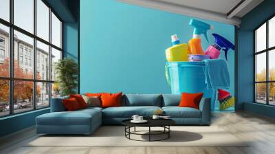 Cleaning products in bucket on blue background Wall mural