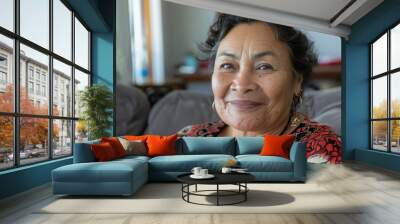 Mature Maori woman sitting indoor at home on couch Wall mural