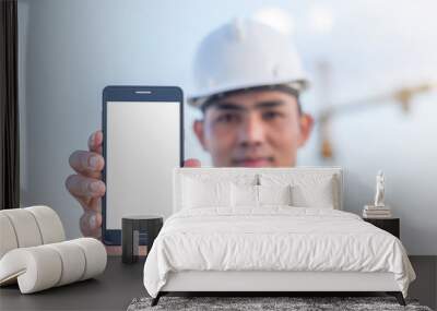 Architects holding a smartphone  isolated white screen with crane background Wall mural