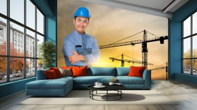 Portrait of engineer wear blue helmet safty on construction site with crane background silhouette Wall mural