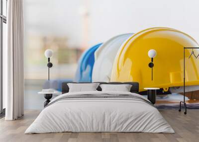 The group of safety helmet and the blueprint at construction site with crane background Wall mural