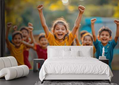 Children celebrating after scoring goal, arms raised in joy, showcasing their excitement and teamwork. vibrant colors of their jerseys add to cheerful atmosphere Wall mural