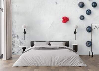 Two meringue nests topped with blueberries and raspberries on a white background with copy space. Wall mural