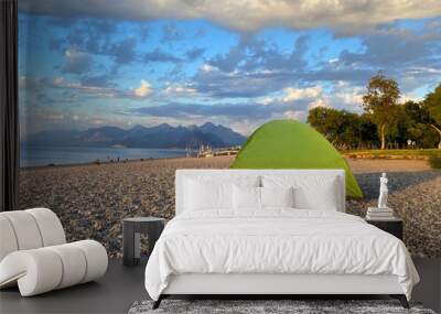 Family camping on the sea beach and mountains in the background, camping tent on the sea or ocean beach, independent tourism Wall mural