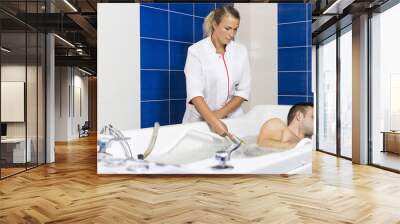 The young man is the procedure in the whirlpool hydrobath  Wall mural