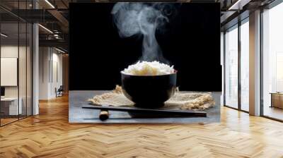 Cooked rice with steam in black bowl on dark background,hot cooked rice in bowl selective focus,hot food and healthy Wall mural