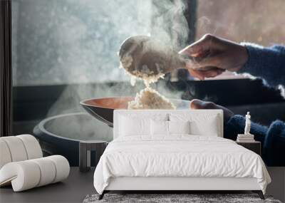 selective focus,soft focus Women hand holding and using wood ladle to scoop steamed rice from electric rice cooker with blur background Wall mural