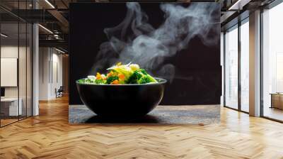 The steam from the vegetables carrot broccoli Cauliflower in a black bowl , a steaming. Boiled hot Healthy food on table on black background,hot food and healthy meal concept Wall mural